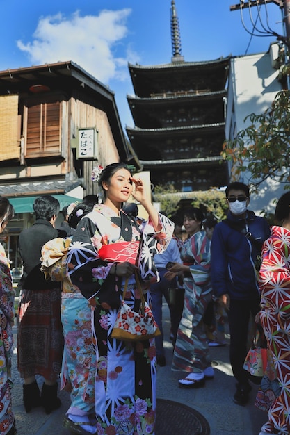 Foto schöne junge frau im kimono steht in der stadt