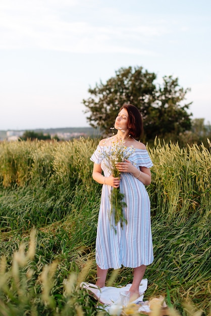 Schöne junge Frau im Sommer in einem Weizenfeld