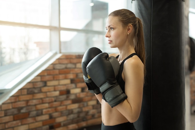 schöne junge Frau in Boxhandschuhen beim Training