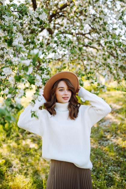 Schöne junge Frau in der Nähe von blühendem Frühlingsbaum Jugendliebe Mode romantisches Lifestyle-Konzept