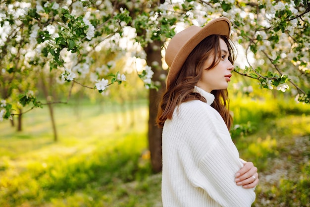 Schöne junge Frau in der Nähe von blühendem Frühlingsbaum Jugendliebe romantisches Konzept