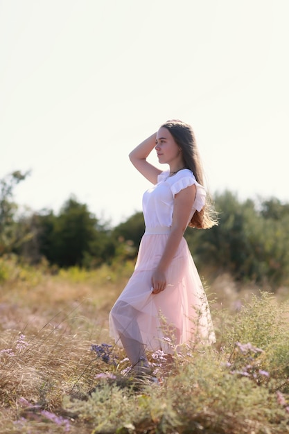 Foto schöne junge frau in der wiese der blumen. natur genießen