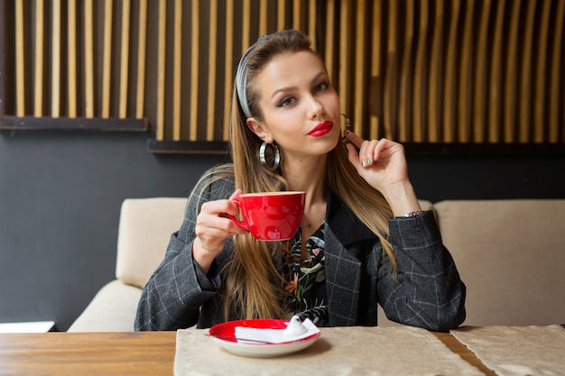 schöne junge Frau in einem Restaurant mit einer Tasse Kaffee