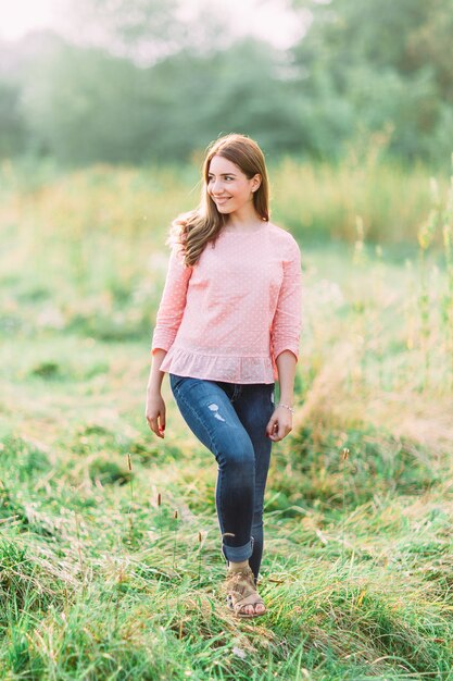 Schöne junge Frau in einem rosa Hemd in der Natur