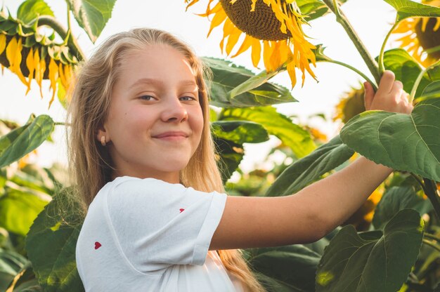 Schöne junge Frau in einem Sonnenblumenfeld. Porträt einer jungen Frau in der Sonne. Pollenallergie-Konzept