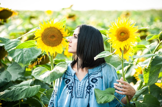 Schöne junge Frau in einem Sonnenblumenfeld