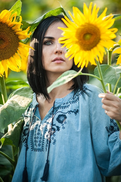 Schöne junge Frau in einem Sonnenblumenfeld