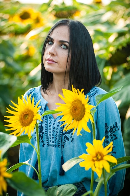 Schöne junge Frau in einem Sonnenblumenfeld