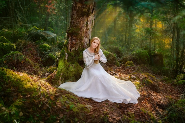 Schöne junge Frau in einem weißen Kleid mitten im Wald