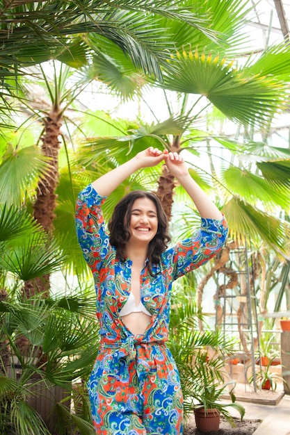 Schöne junge Frau in Sommerkleidung in einem tropischen Ferienort