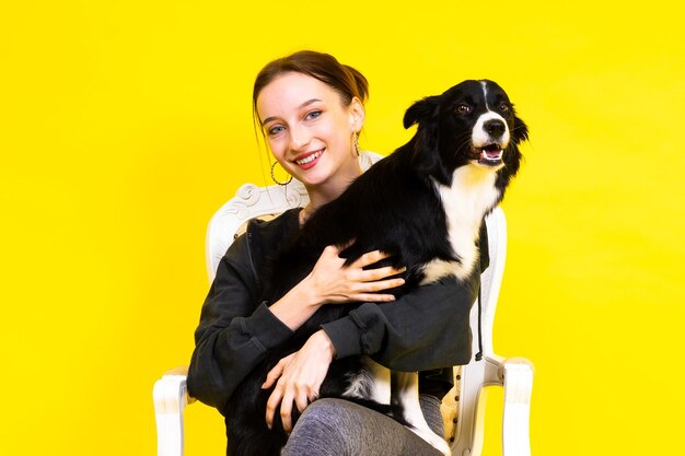 Schöne junge Frau küsst und umarmt ihren Welpen Border Collie Hund Liebe zwischen Besitzer und Hund