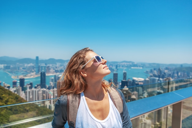 Schöne junge Frau lächelt glücklich und setzt ihr Gesicht zur Sonne