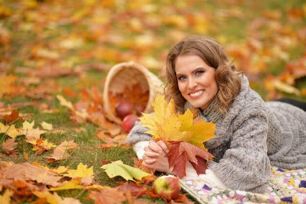 Foto schöne junge frau lächelt und posiert im herbstpark