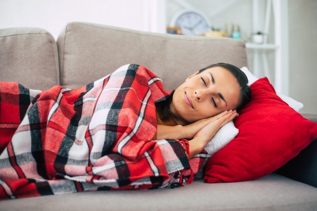 Schöne junge Frau liegt auf der Couch