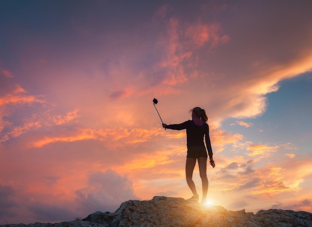 Schöne junge Frau macht Selfie für Instagram bei Sonnenuntergang