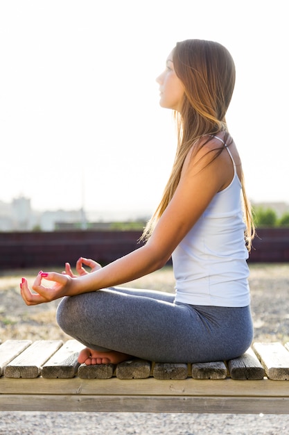 Schöne junge Frau macht Yoga auf der Straße.