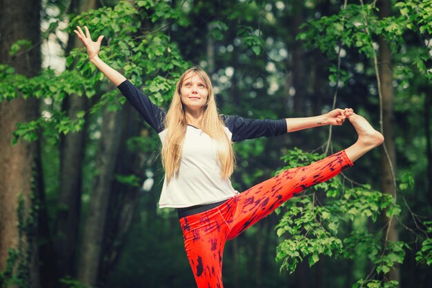 Schöne junge Frau macht Yoga im Park