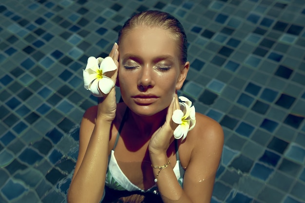 schöne junge Frau mit blauen Augen im Pool