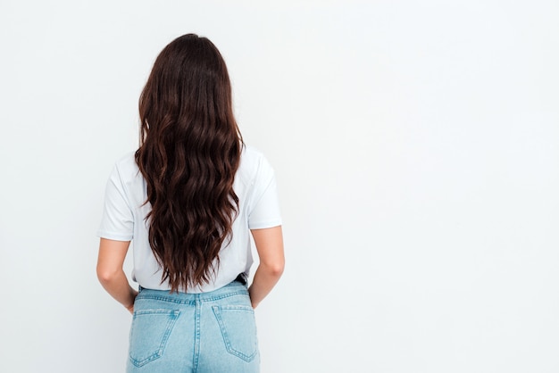 Schöne junge Frau mit dem langen dunklen Haar, das eine Shirtaufstellung trägt