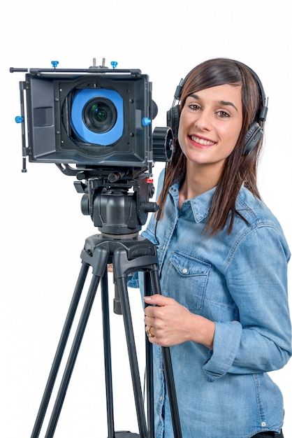 Schöne junge Frau mit DSLR-Videokamera und Kopfhörern