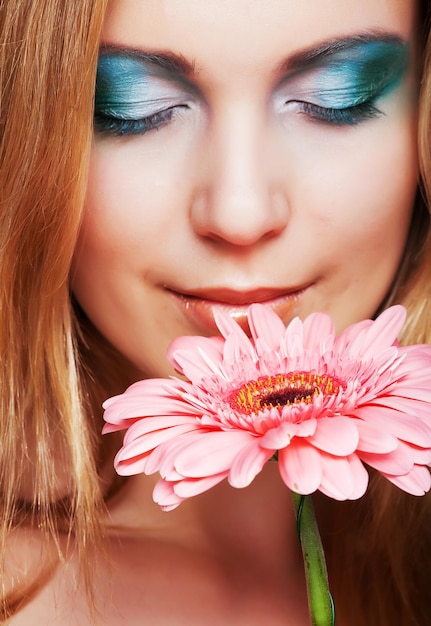 Foto schöne junge frau mit gerber blume