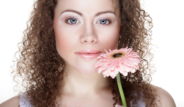 Schöne junge Frau mit großem rosa Gerber