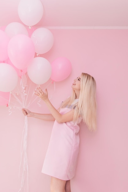 Schöne junge Frau mit Herzform Heißluftballon auf farbigem Hintergrund Frau am Valentinstag Symbol der Liebe