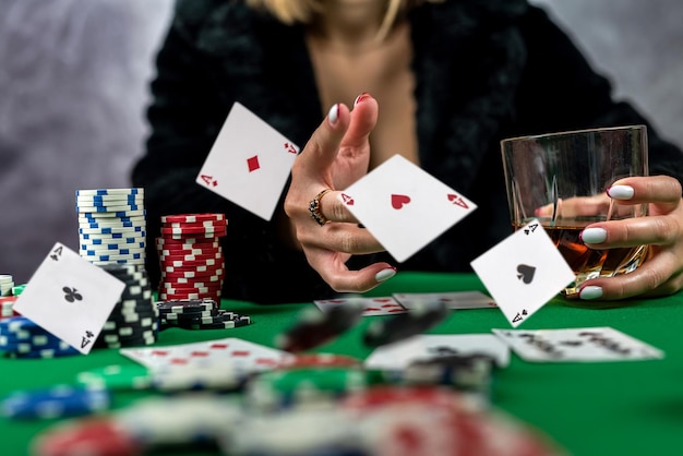 Schöne junge Frau mit Karten in ihren Händen macht eine Kartenbewegung beim Poker