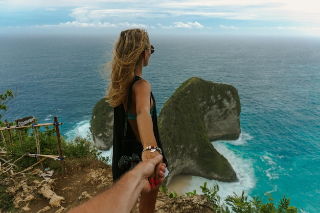 Schöne junge Frau mit langen Haaren in Manta Bay. Luftbild von Kelingking Beach (Manta Bay) ist einer der berühmtesten und schönsten Orte in Nusa Penida, Insel in der Nähe von Bali. Indonesien.