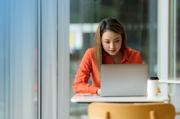 Schöne junge Frau mit Laptop