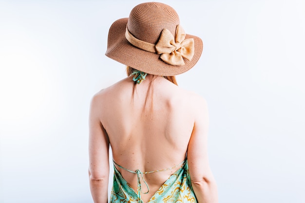 Schöne junge Frau mit Sommerkleid, Pamela von hinten auf weißem Hintergrund mit Platz für Kopie. Sommerurlaub Konzept