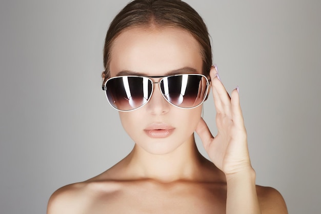 Schöne junge Frau mit Sonnenbrille