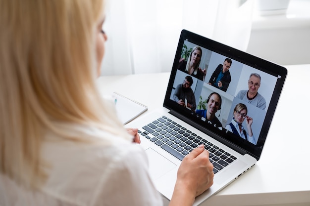 Schöne junge frau mit videokonferenz über computer. anruf konferenz. heimbüro. bleiben sie zu hause und arbeiten sie von zu hause aus während der coronavirus-pandemie