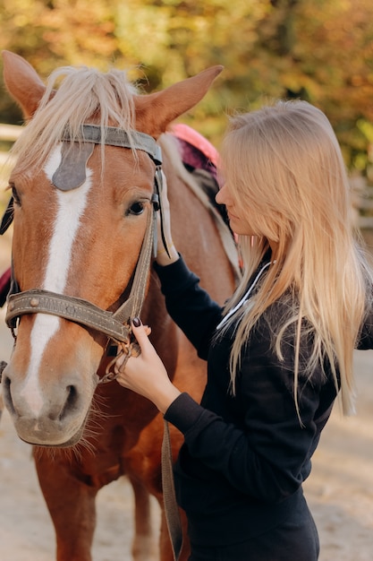 Schöne junge Frau nahe Pferd