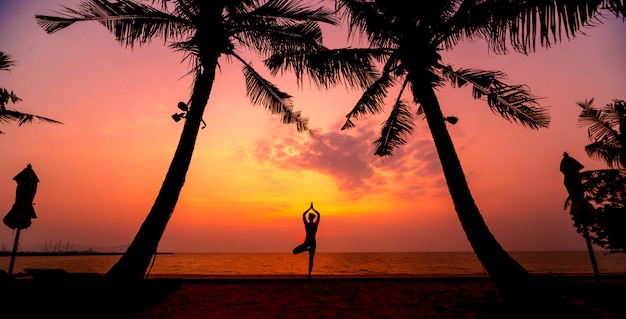 Schöne junge Frau praktizieren Yoga am Strand. Übung am frühen Morgen. Sonnenaufgang