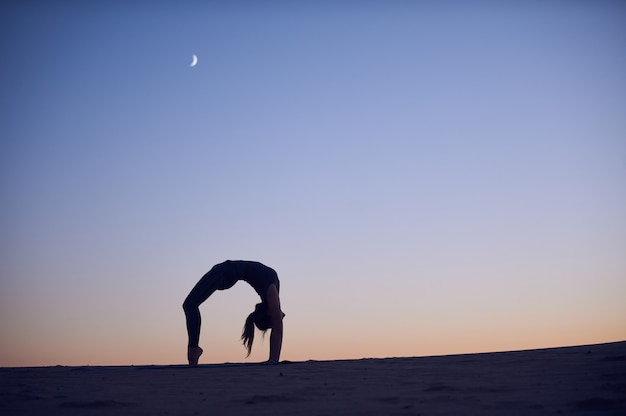 Schöne junge Frau praktiziert Backbend Yoga Asana Urdhva Dhanurasana