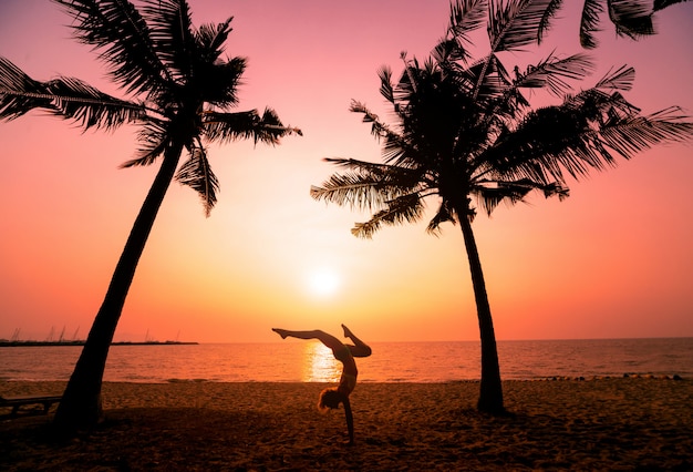 Schöne junge Frau praktiziert Yoga am Strand. Übung am frühen Morgen