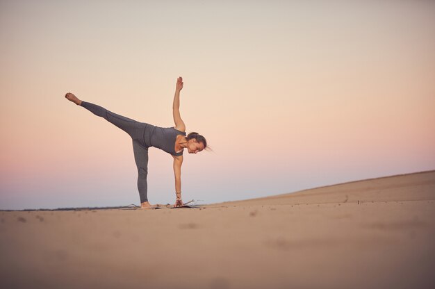 Schöne junge Frau praktiziert Yoga Asana Ardha Chandrasana