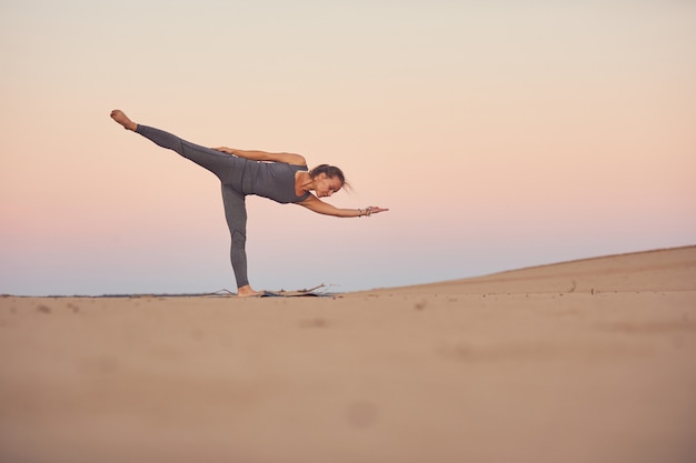 Schöne junge Frau praktiziert Yoga Asana Ardha Chandrasana