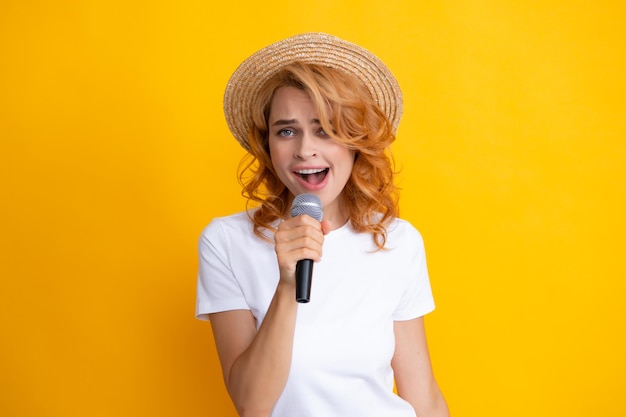 Schöne junge Frau singt Karaoke isoliert auf gelb Mädchen singt Soundtrack-Song am Mikrofon
