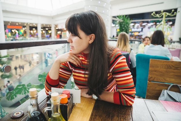 schöne junge Frau sitzt in einem Einkaufszentrum Café