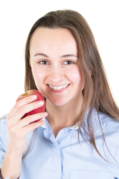 Schöne junge Frau über weißer Wand, die roten Apfel mit glücklichem Gesicht isst und mit einem selbstbewussten Lächeln lächelt, das Zähne zeigt