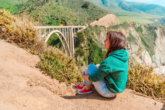 schöne junge Frau und die malerische Bixby Creek Bridge an der Big Sur Coast