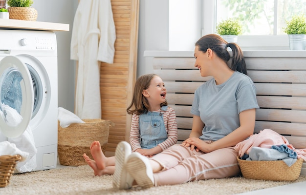 Schöne junge Frau und kleiner Helfer des Kindermädchens haben Spaß und lächeln