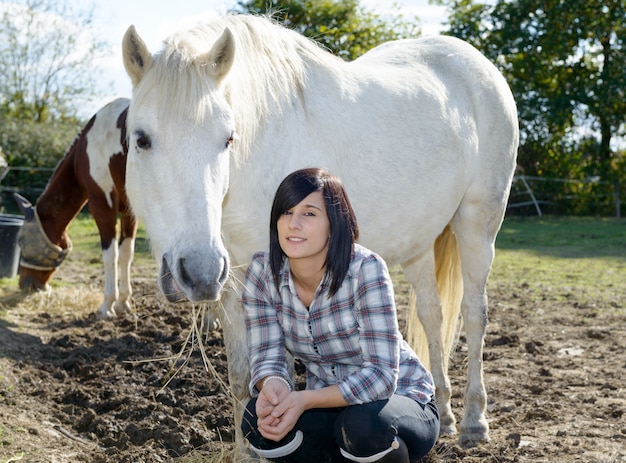 Schöne junge Frau und weißes Pferd