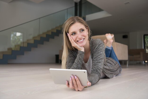 schöne junge Frauen benutzten Tablet-Computer auf dem Boden ihres Luxushauses