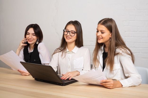 schöne junge Frauen im Büro mit Laptop