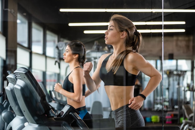 Schöne junge Frauen laufen auf Laufbändern im Fitnessstudio