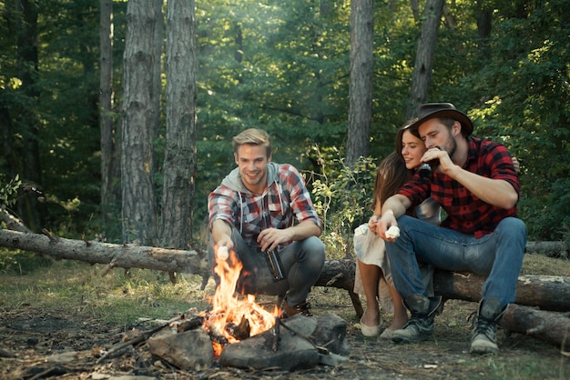 Schöne junge Freunde, die ein Picknick in einem Park-Picknick-Zeitpicknick mit Freunden im Wald in der Nähe von Bon genießen...