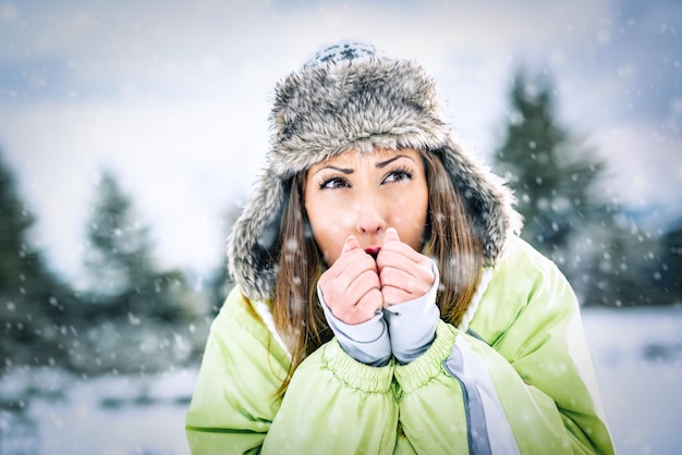 Schöne junge gefrorene Skifahrerin in den Winterferien, stehend und wegschauend.